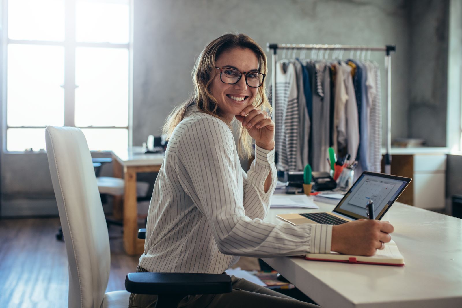 Woman satatdesk writingonpad