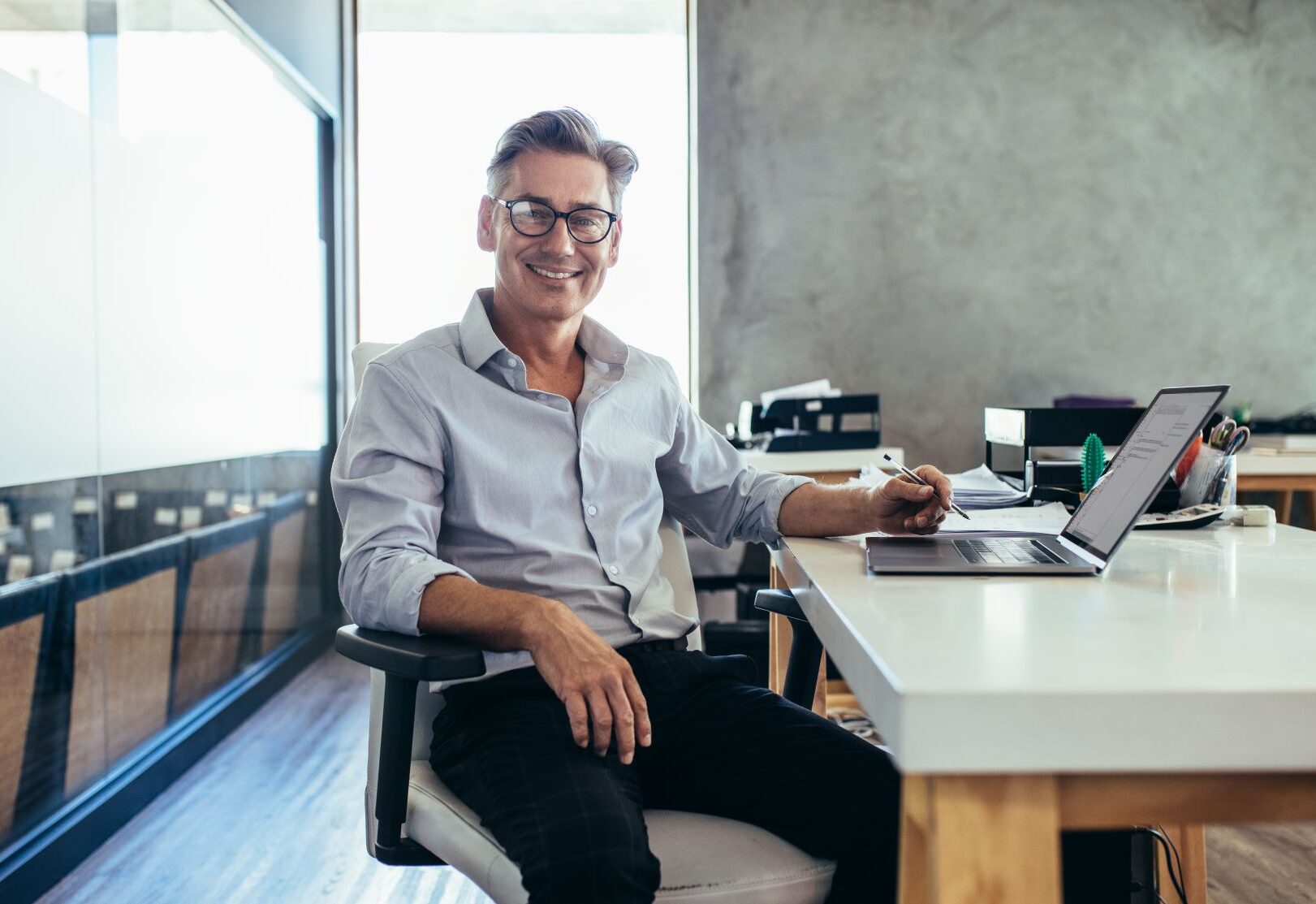 male businessman smiling desk medium e1696005067811