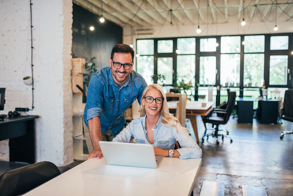 man woman laptop smiling