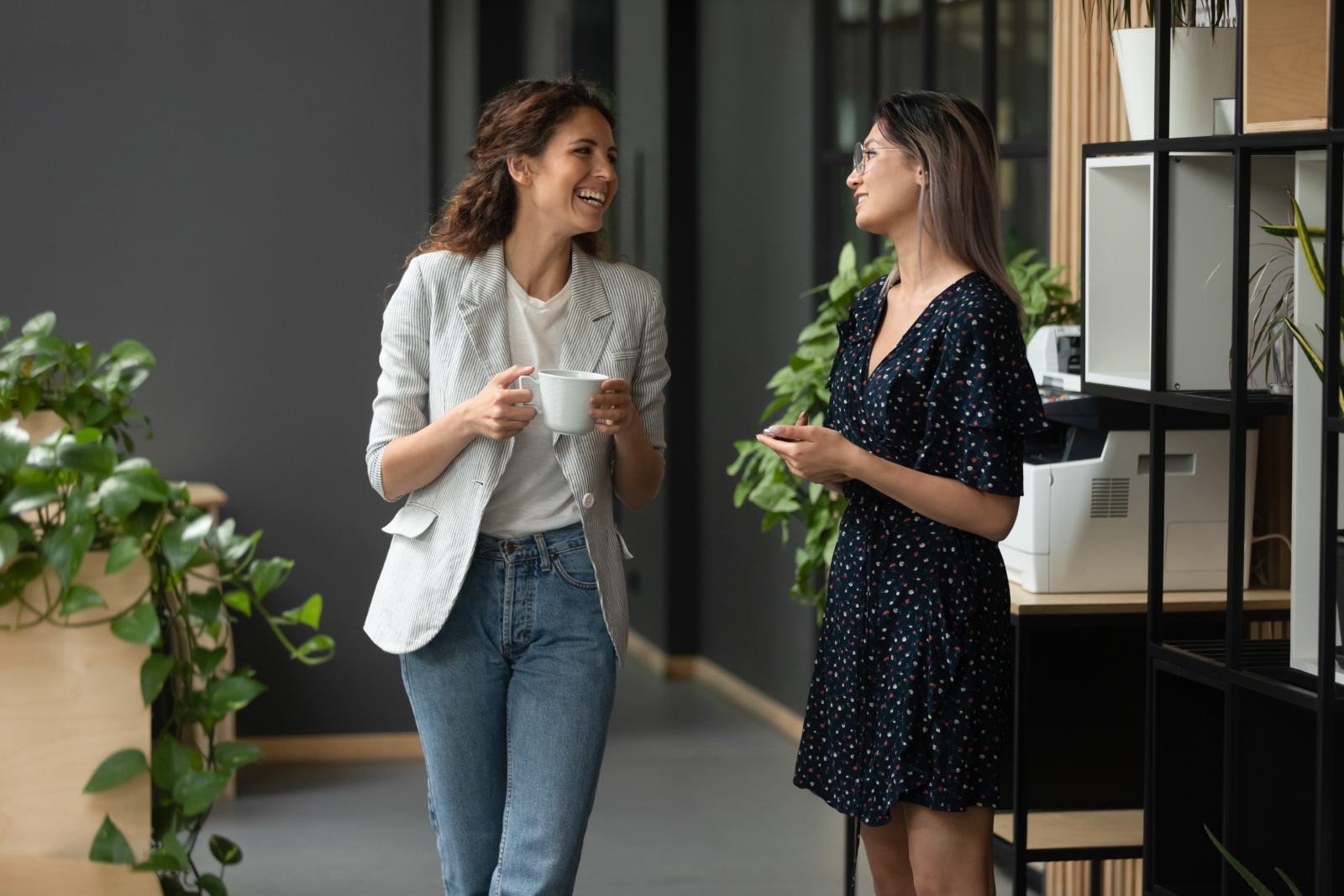 two business-women chatting in an office hallway