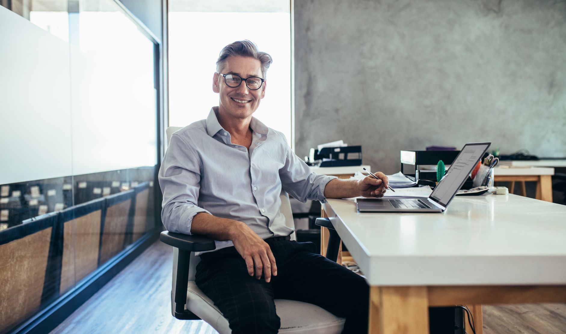 male businessman smiling desk medium