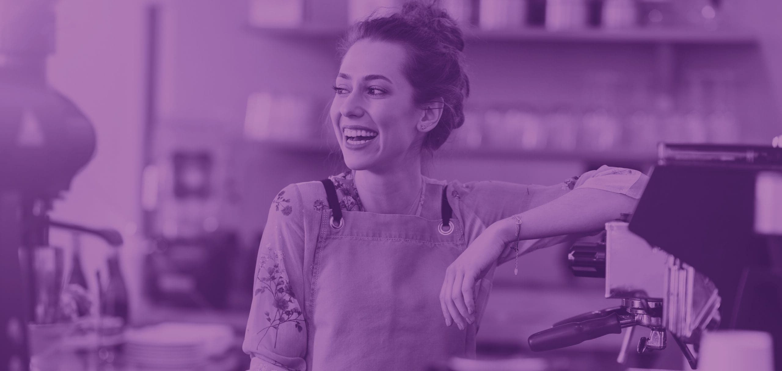 Person Leaning Against a Coffee Machine Whilst Smiling in the Opposite Direction